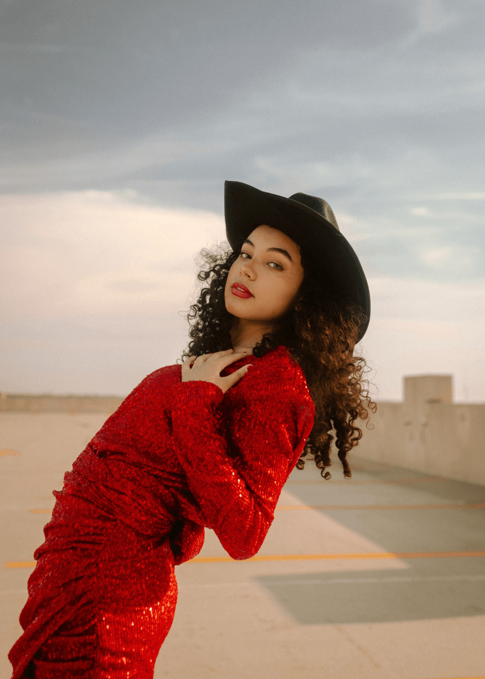 a woman in a red dress and a black hat